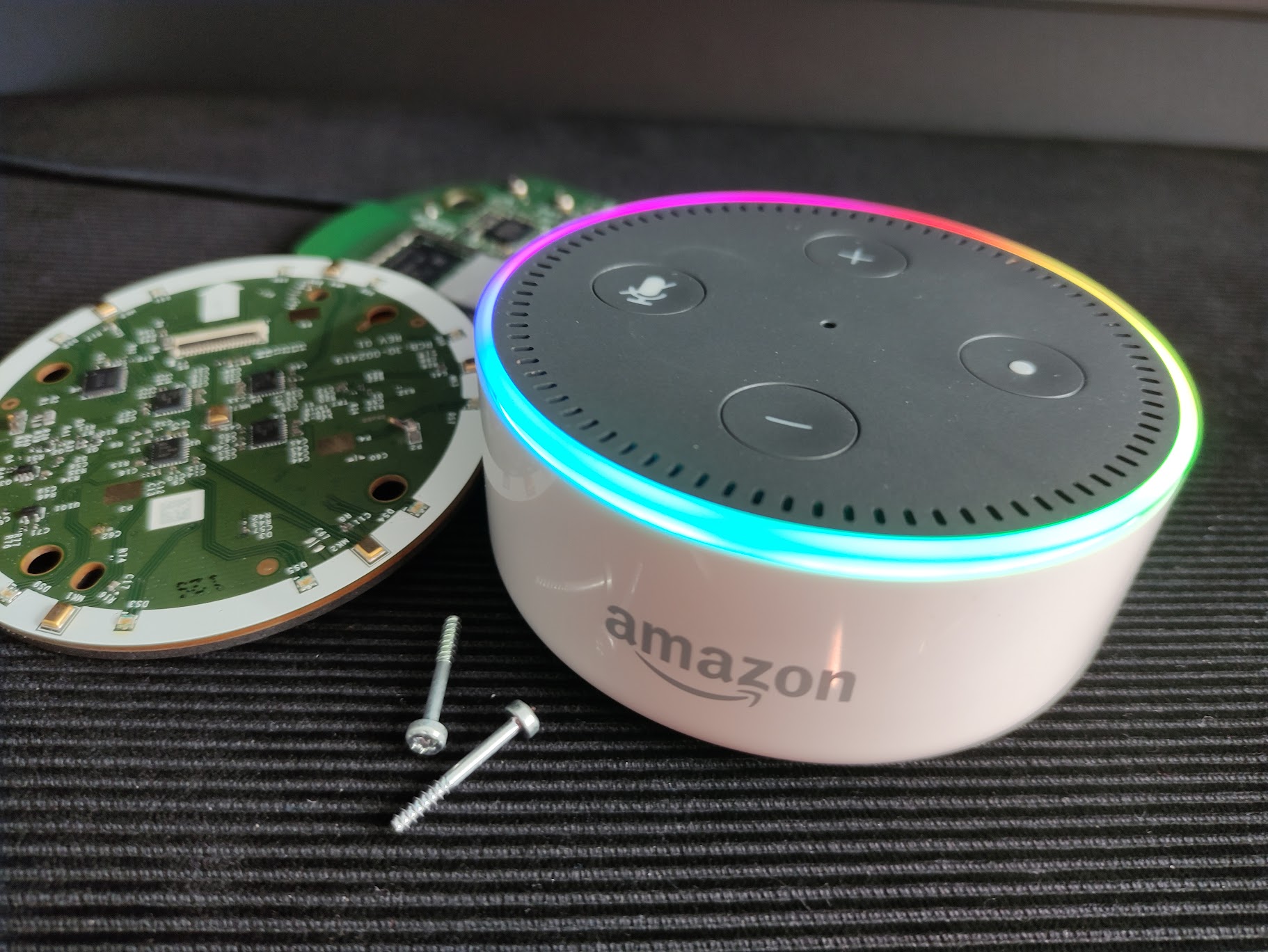 A white amazon echo dot 2nd generation with rainbow lights on its LED ring